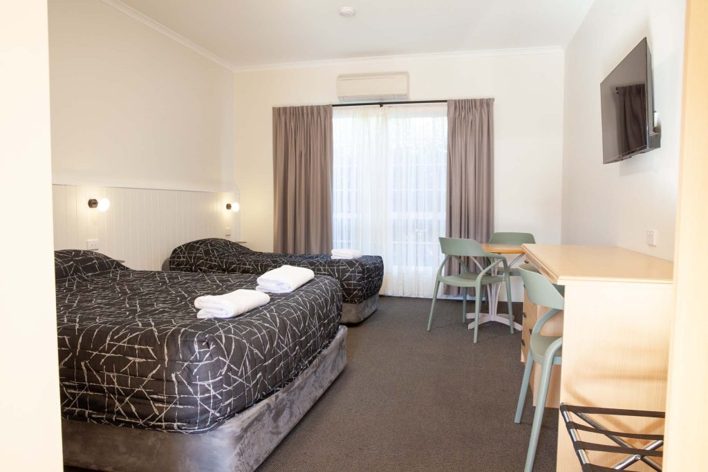 the kidman wayside inn room featuring two beds with black and white patterned comforters